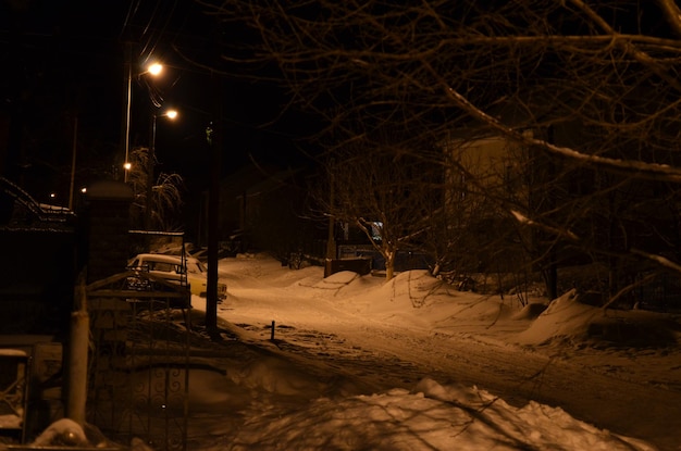 Una calle nevada por la noche con un cartel que dice "nieve".