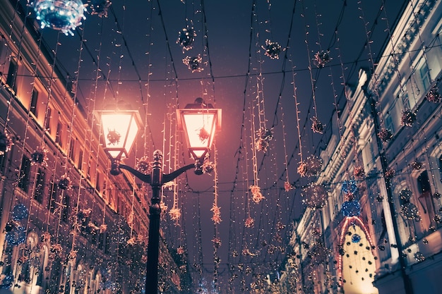 Calle nocturna con decoración navideña en Moscú, Rusia. Paisaje nocturno de invierno. Luces y guirnaldas festivas que brillan intensamente