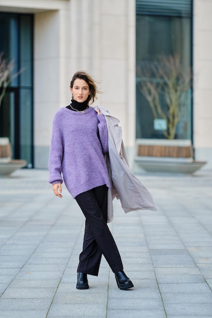 Calle retrato de una mujer con impermeable sobre su hombro