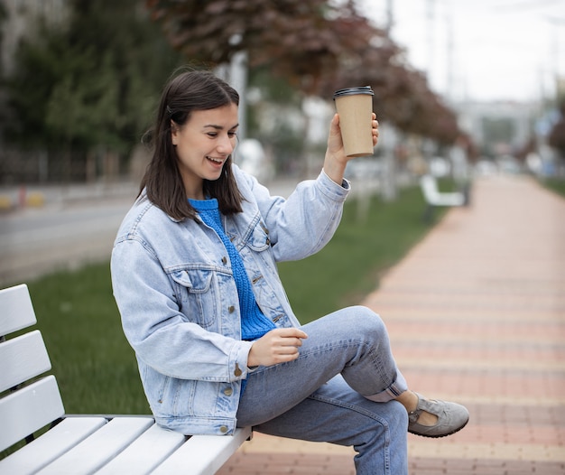 Calle retrato de una mujer joven alegre en un paseo con café