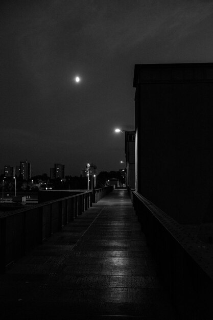 Foto calle vacía iluminada en medio de edificios por la noche