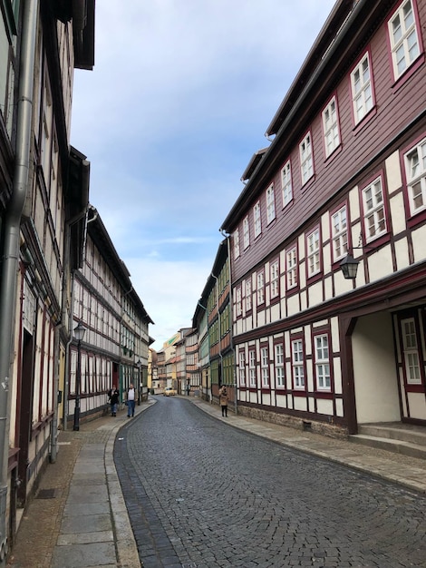 Calle vacía en medio de edificios en la ciudad contra el cielo