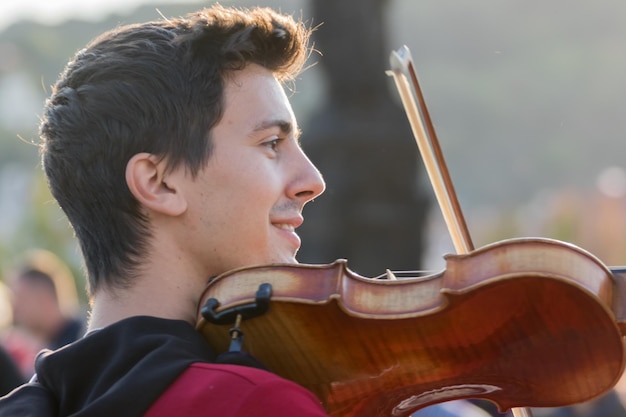 Calle violinista con violín y arco en sus manos