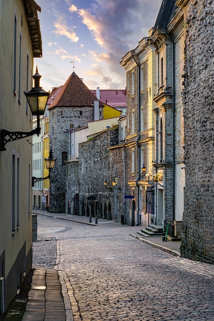 Callejón medieval a lo largo del muro de piedra en la ciudad de Tallin al amanecer.