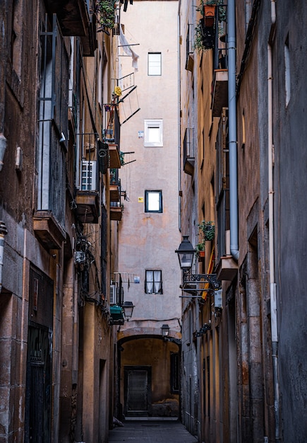 Callejón en medio de edificios en la antigua parte medieval de la ciudad de Barcelona, España.