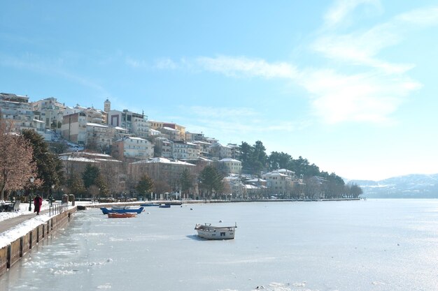 Foto callejón peatonal en las orillas del lago congelado orestiada en kastoria grecia en un día soleado