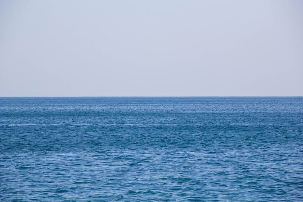 Calma do mar azul acena a superfície macia do oceano e do céu azul.