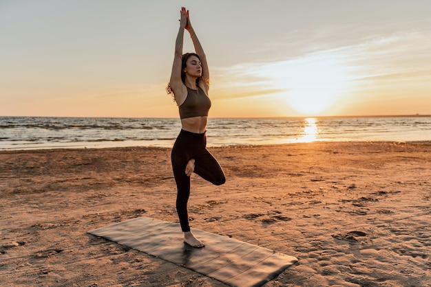 Calma e harmonia Equilíbrio e meditação mulher treinando yoga asana ao ar livre perto do lago