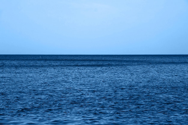 Calma mar azul ondas superfície macia oceano e céu azul na cor azul clássica da moda