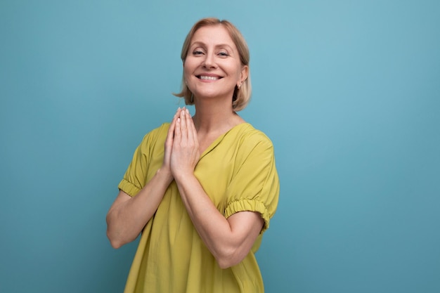 Calma mujer de mediana edad puso sus manos juntas para la oración