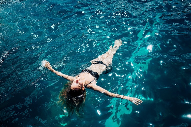 Calma mujer relajada en el agua nadando