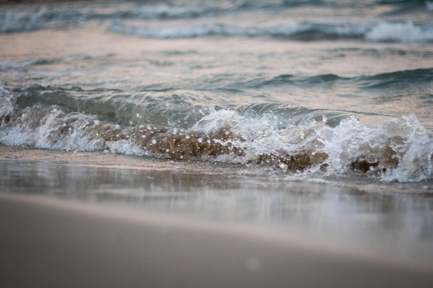Calma y tranquilidad Primer plano y detalle de las olas en la orilla del fondo de la playa