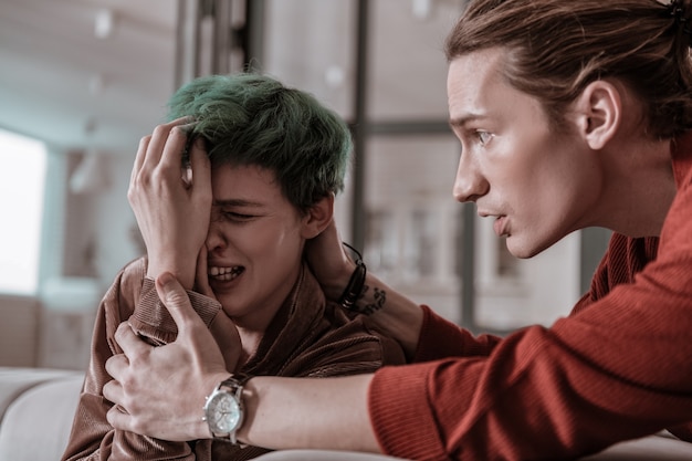 Foto cálmate. esposo emocional preocupado calmando a su esposa llorando con hemorragia nasal