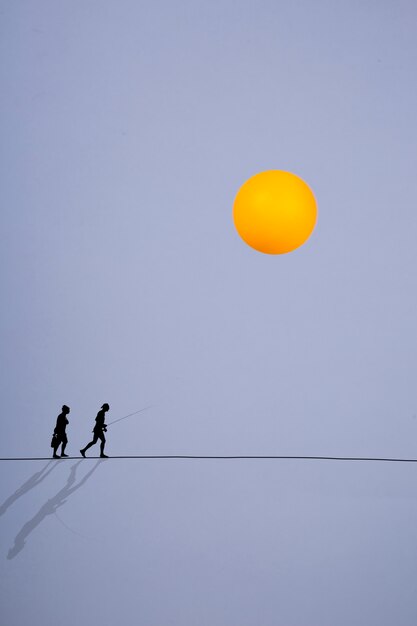 Calor. Collage con siluetas de un hombre y una mujer sobre la que brilla el sol.