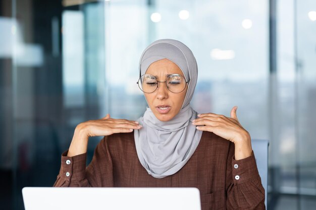 Calor e calor na mulher de negócios do escritório em hijab acenando com as mãos tentando refrescar e esfriar