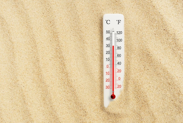 Caluroso día de verano Termómetro de escala Celsius y Fahrenheit en la arena Temperatura ambiente más 32