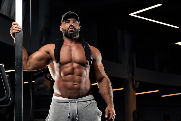 Calvo brutal sexy fuerte culturista atlético fitness hombre bombeando músculos abdominales entrenamiento culturismo concepto fondo