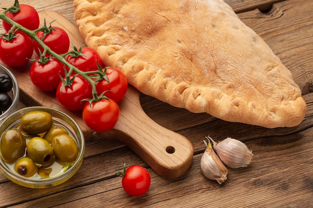 Calzone de alto ángulo, tomates y aceitunas