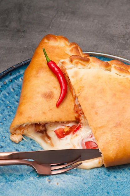 Calzone de pizza caliente jugosa con mozzarella y tomates