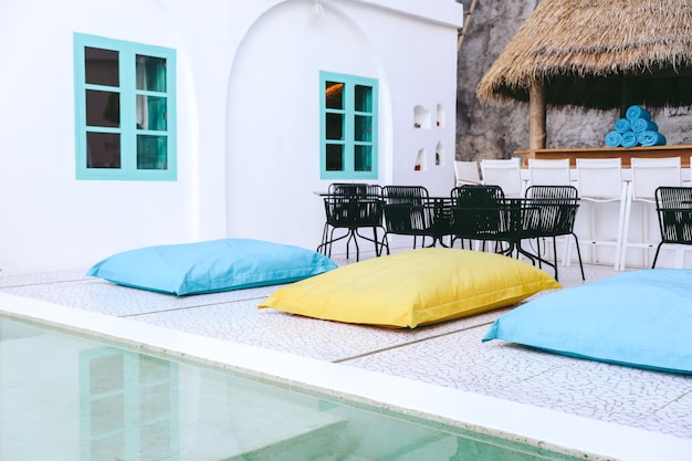 Cama de almohada colorida o bolsa de frijoles cerca de la piscina