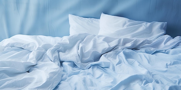 Foto cama azul desordenada con ropa de cama blanca