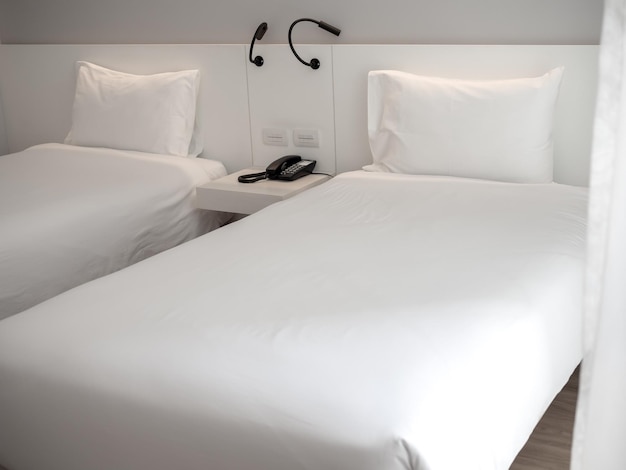 Cama blanca limpia con almohadas blancas en la habitación del hotel