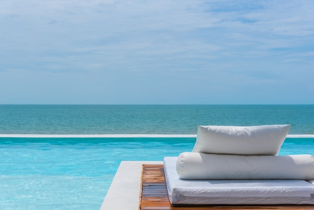 Cama blanca en la piscina junto al mar el mar con horizonte