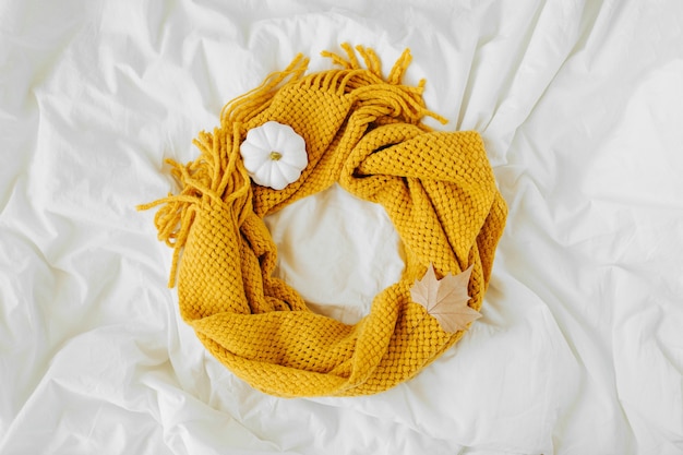 Foto cama com lenço amarelo de malha. fundo aconchegante. conceito de outono.