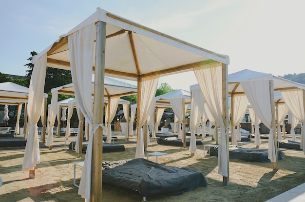 Cama de cabana ao ar livre na praia de areia em um dia ensolarado na costa do Adriático e no mar na Eslovênia