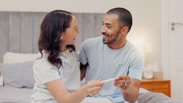 Cama de casal entusiasmado e teste de gravidez positivo para início de família ou maternidade em casa Rosto de homem feliz e mulher grávida sorriso para manhã de paternidade ou boas notícias ou resultados no quarto juntos