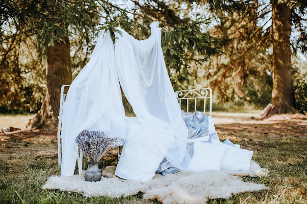 Cama de dossel de Photozone na floresta na natureza. o tecido esvoaçava ao vento. Lugar para foto da noiva. sessão de fotos