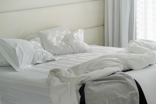 Foto cama de hotel após o uso. cama suja travesseiro quarto.