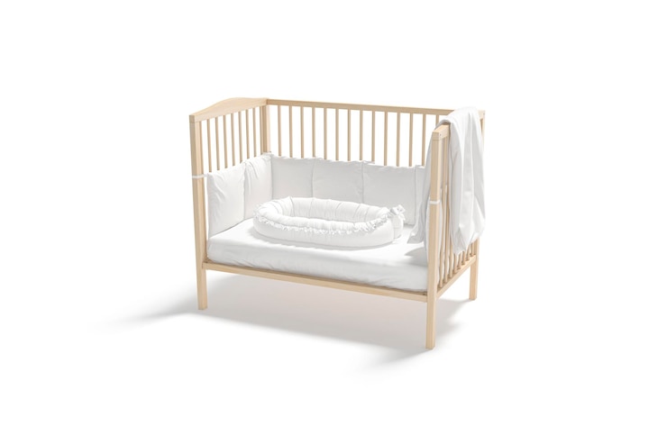 Foto cama de madeira em branco com lençol de berço branco e modelo de ninho