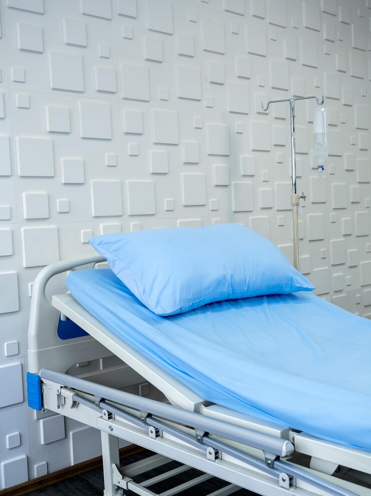 Foto cama de paciente vazia em um quarto de hospital com travesseiro azul e lençol no estilo vertical de fundo de parede branca cama doente na sala de recuperação com fundo ajustável elétrico conceito médico de cuidados de saúde