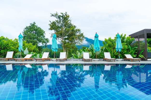 Cama de piscina ao redor da piscina com fundo de colina de montanha