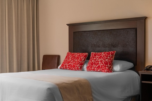 cama doble de hotel con cojines rojos