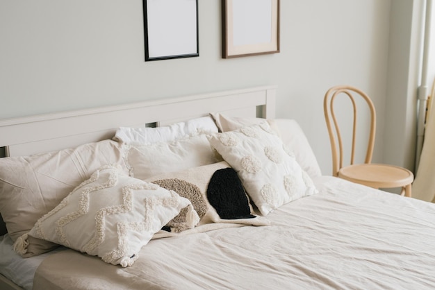 Cama en el dormitorio en un estilo minimalista escandinavo Almohadas ligeras en la cama Decoración sobre la cama