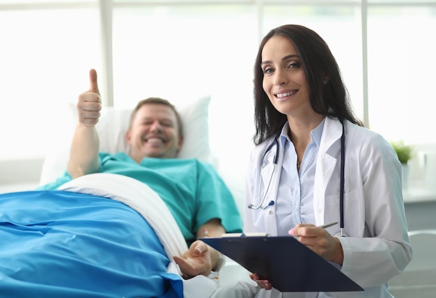 Foto cama de hospital hombre muestra gesto aprobación médico