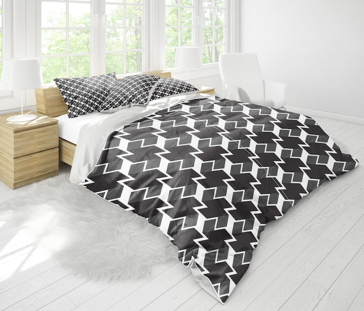 una cama negra y blanca con un cobertor negro y blanco