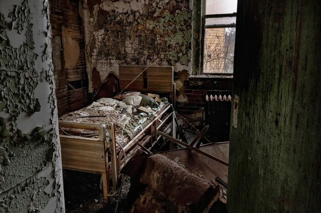 Foto cama num quarto abandonado.