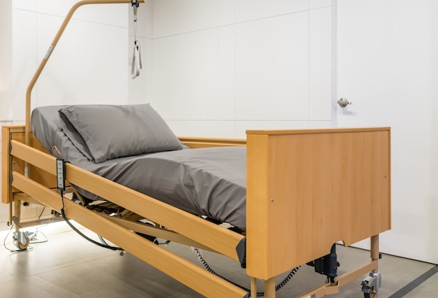 Cama de paciente eléctrica ajustable en la habitación del hospital. Tecnología de servicios médicos y hospitalarios.