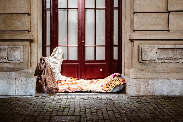 Cama de una persona sin hogar frente a la casa urbana de Porto Portugal