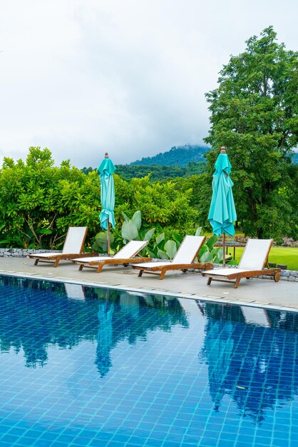 Cama de piscina alrededor de la piscina con fondo de colina de montaña