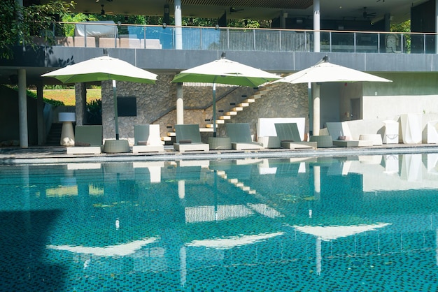 Cama piscina con sombrilla alrededor de la piscina