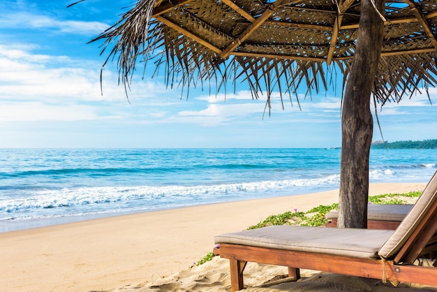 Cama de playa con sombrilla en la playa tropical