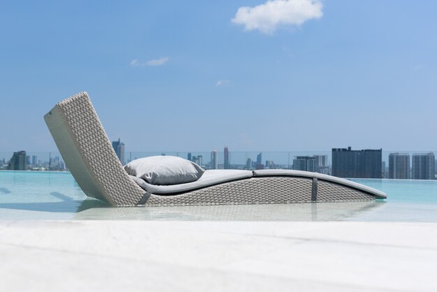 Cama relajante o de ocio en la piscina con cielo azul y nubes