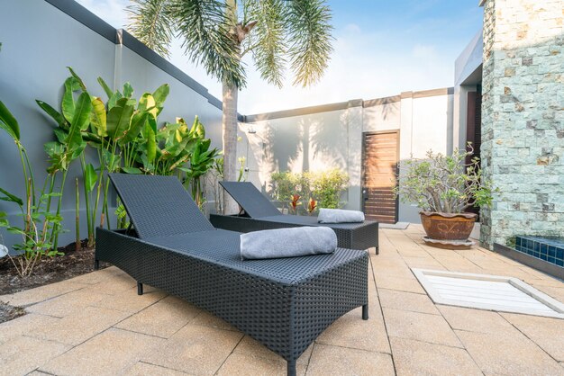 Foto cama solar con sombrilla y plantas verdes en la casa o edificio de la casa.