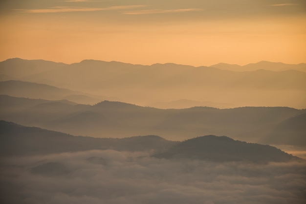 Camada de montanhas e neblina durante o pôr do sol
