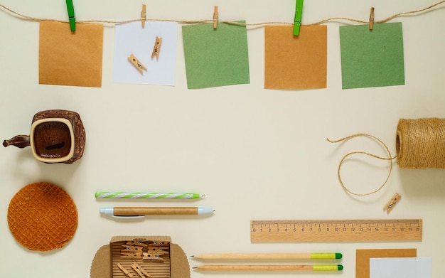 Foto camada plana de adesivos de papel kraft com prendedores de roupa, café e papelaria