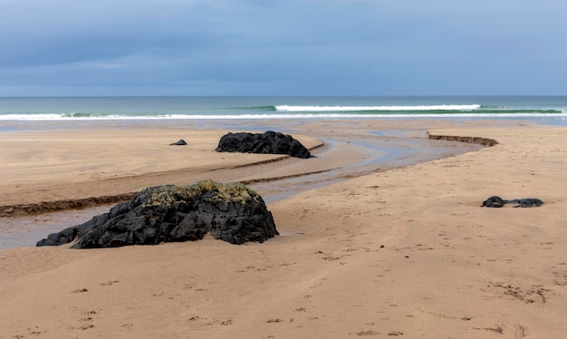 Camadas de uma maré enchente e praia rochosa em Downhill Beach em Downhill Demesne, no condado de Londonderry, na Irlanda do Norte. Localização do tiroteio de Game of Thrones